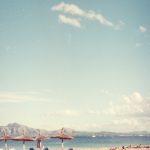 a sandy beach with chairs and umbrellas on it